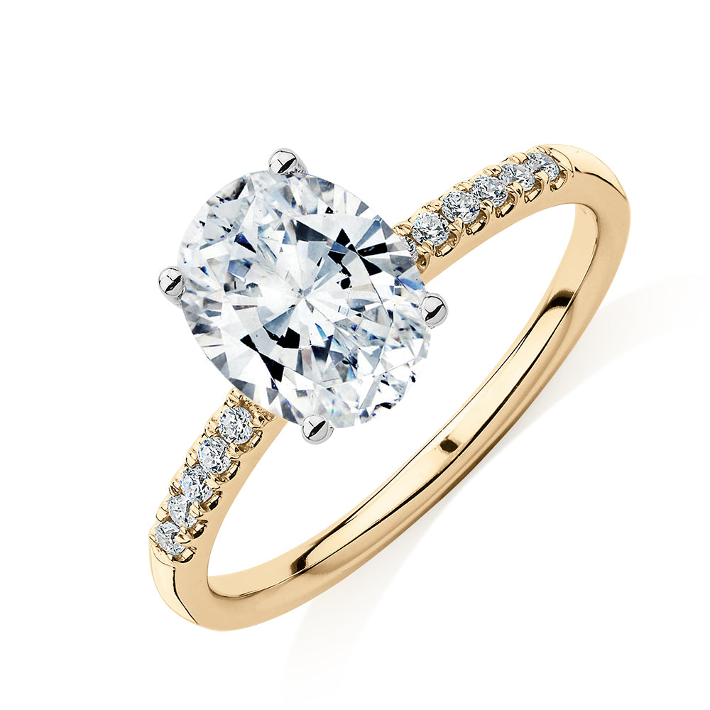 Oval and Round Brilliant shouldered engagement ring with 1.94 carats* of diamond simulants in 14 carat yellow and white gold